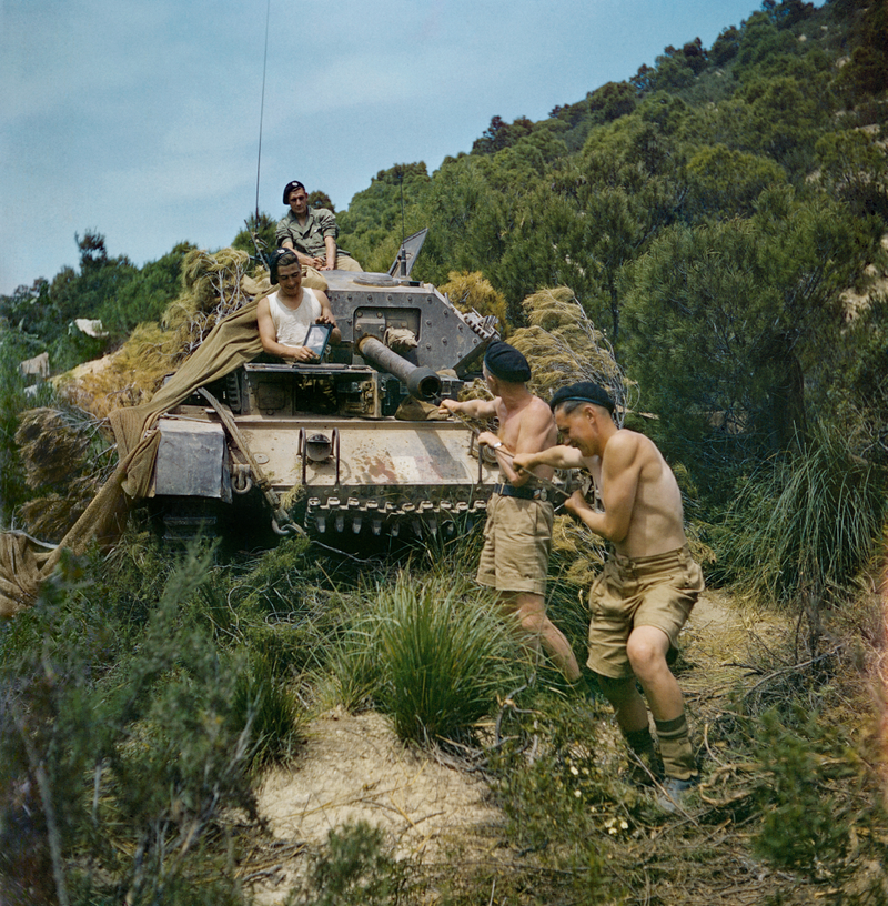 A crew from the 16th/5th Lancers, 6th Armoured Division, clean the gun barrel of their Crusader tank at El Aroussa in Tunisia, May 1943. (Image: IWM)